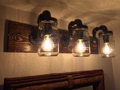 three mason jar lights are hanging on the wall