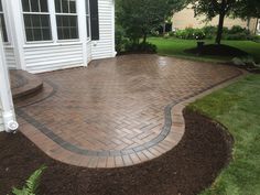 a brick patio in front of a white house