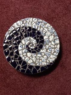 a circular metal object with blue and white designs on it