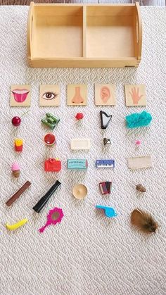 an assortment of different items on the floor in front of a wooden box with letters and numbers