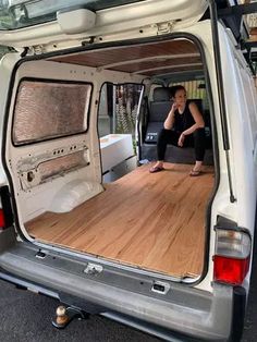 a woman sitting in the back of a white van