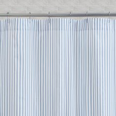 a blue and white striped shower curtain next to a toilet