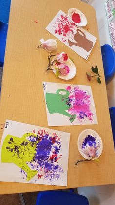 the table is covered with paper plates and paint