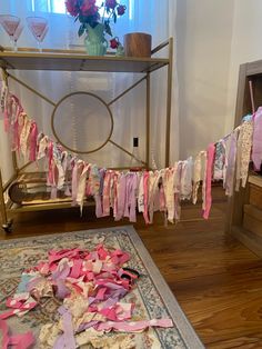 a bunch of clothes that are laying on the ground in front of a table with flowers