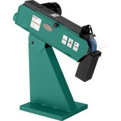 a machine that is sitting on top of a green stand with two pieces of paper sticking out of it