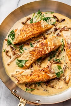 some fish is in a white sauce with spinach