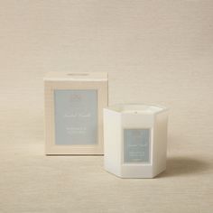 a white candle sitting next to a box