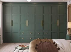 a bedroom with green cupboards and white sheets on the bed in front of it