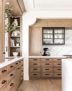 a kitchen with wooden cabinets and marble counter tops