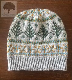 a knitted hat sitting on top of a wooden table next to a brown tree