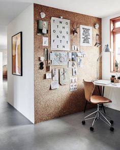 a room with a desk, chair and pictures on the wall in front of it