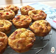 small muffins cooling on a wire rack in front of a cookbook and napkin