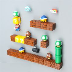 some nintendo figurines are placed on top of a brick wall with mario and luigi in the middle