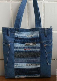 a blue jean bag hanging on a white brick wall