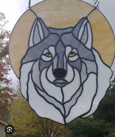 a stained glass window with a wolf head on it's side and trees in the background