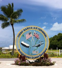 there is a sign that says diego garcia air terminal in front of the palm tree