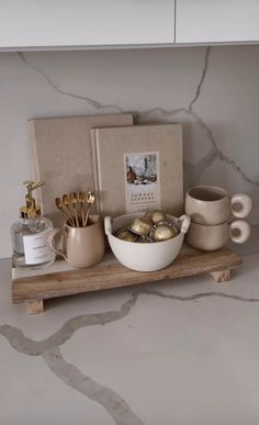 a counter with various items on it including cups, spoons and an open book