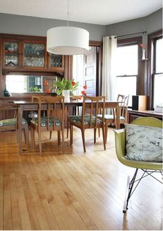 a dining room table and chairs in front of a window with wooden cabinets on either side