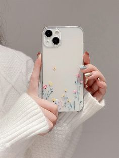 a woman holding an iphone case with flowers on it