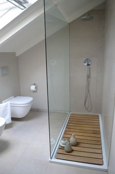 a bathroom with a glass shower door, toilet and bathtub in the corner next to each other