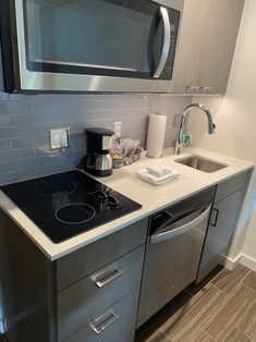 a kitchen with stainless steel appliances and white counter tops, including a microwave above the stove