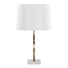 a table lamp with a white shade on the base and a gold colored metal frame