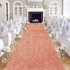 the aisle is decorated with white flowers and silver vases, along with an orange carpet