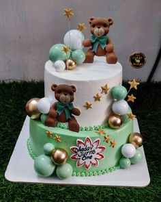 a three tiered cake decorated with teddy bears and stars on it's sides