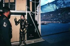 a man and woman dressed up in costumes standing next to each other at a concert