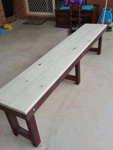 a wooden bench sitting on top of a cement floor