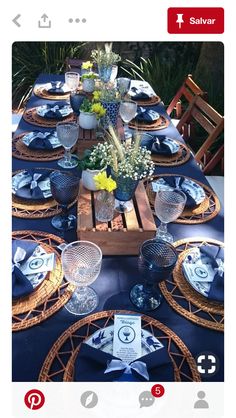 the table is set with blue and white plates, napkins, and vases