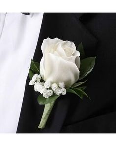 a white rose and baby's breath boutonniere on a black suit