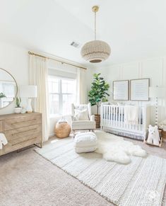 a baby's room with white furniture and decor