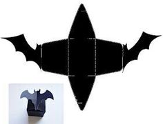 an origami bat hanging from the side of a wall with paper cut outs