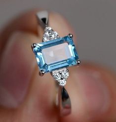 100% Natural Gemstone, Swiss Blue Topaz Jewellery Ring, 925 Sterling Silver Ring, Birthstone Ring, Authentic Ring, Anniversary Ring, Topaz Zircon Ring Stone Name  :-  Swiss Blue Topaz Secondary Stone :-  Zircon Stone Shape  :- Rectangle Cut Stone Size     :- 8x6 MM Material    :- 925 Sterling silver Accept Custom Orders Service. ❁❁ 𝐉𝐞𝐰𝐞𝐥𝐫𝐲 𝐂𝐞𝐫𝐭𝐢𝐟𝐢𝐜𝐚𝐭𝐞 ❁❁ ↣ KHJewels branded authenticate Jewellery Certificate comes with the authenticity of Metal, Moissanite, and Gemstone combination. ↣ The certificate comes with Limited Lifetime Warranty details. ↣ Listed Jewellery comes with a branded Jewellery Certificate on request. ↣ If you want to get the certificate with your ordered jewellery then please contact me within 72 hours of your order placed. ↣ The certificate is Chargeable Square Diamond Rings, Blue Engagement Ring, Blue Topaz Jewelry, Princess Cut Rings, Gem Ring, Zircon Ring, Swiss Blue Topaz, Blue Topaz Ring, Topaz Ring