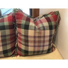 two plaid pillows sitting on top of a couch