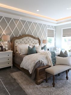 a bedroom with a large bed and white furniture