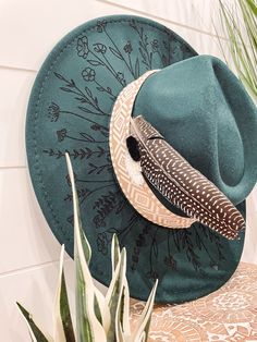 Wildflower Floral Burned Hat, Floral Engraved Cowboy Hat, Sunflower Hat, Sunflower Burned Fedora, Engraved Fedora, Engraved Felt Hat, Boho Hat Elevate your style with our beautifully engraved floral hats! If you want certain colors for the feather/flower detail, please leave a note at checkout. Bands and florals/feathers may shift or fall off during shipping. The hat has an adjustable band on the inside to fit many sizes. One size fits most adult heads. Wood Burning Diy, Cowboy Hut, Hat Burning, Sunflower Hat, Cowboy Hat Design, Painted Hats, Women Hats Fashion, Boho Hat, Chapeau Cowboy