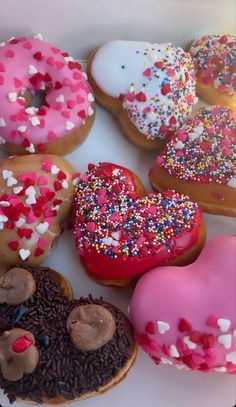 a box filled with lots of different flavored doughnuts covered in sprinkles