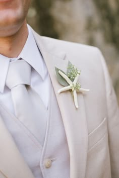 a man in a suit and tie with a boutonniere on his lapel