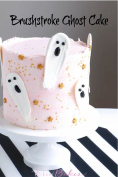 a pink cake decorated with white frosting and ghost decorations