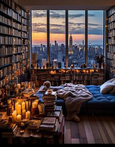 a room filled with lots of books next to a window covered in candles and blankets