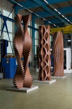 three large wooden sculptures sitting inside of a building