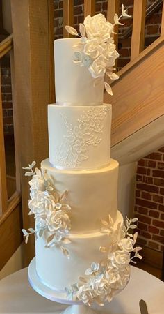 a three tiered white wedding cake on top of a table