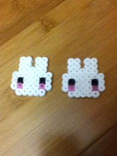 two pieces of white perlery with black dots on them, one has a pink nose