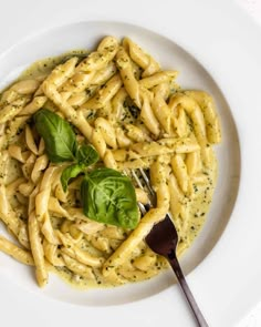 a white plate topped with pasta and pesto