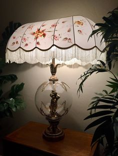 a lamp that is sitting on top of a table next to a potted plant