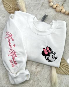 Cozy up in a bit of magic with our enchanting, Magical Autograph crewneck sweater. This sweater has a soft blended interior and features an embroidered face of the beloved Mrs. Mouse on the left side of the chest and her autograph alongside the right sleeve. It could not get any cuter than this! ✦Sweater design features two embroidered locations. ✦Choose your preferred colored crew! ✦Interested in a different character? Head over to our "All Crewnecks" tab or type 'Magical Autograph Crewneck' in the search bar to see the other characters! ✦Want to pair this sweater with our mouse ears? Browse our ear selection to find your favorite match! Disney Birthday Sweatshirt, Cute Crew Neck Sweatshirt With Embroidered Logo, White Long Sleeve Sweater With Embroidered Logo, Cute Crew Neck Embroidered Sweatshirt, Cute White Crew Neck Sweater, Embroidered Crew Sweater For Winter, Cute Winter Sweatshirt With Embroidered Text, Cute Crew Neck Sweater With Embroidered Logo, Cute Embroidered Long Sleeve Sweatshirt