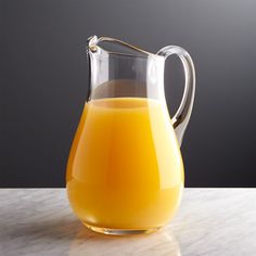 a pitcher filled with orange juice on top of a table