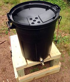 a large black barrel sitting on top of a wooden pallet